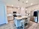 Modern kitchen features an island with a sink and seating, stainless steel appliances, and elegant pendant lighting at 6293 Bradford Woods Dr, Zephyrhills, FL 33542