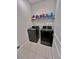 Modern laundry room equipped with gray front load washer and dryer and shelving at 6293 Bradford Woods Dr, Zephyrhills, FL 33542