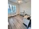 Well-lit home office space featuring wood-look flooring and plantation shutters at 6293 Bradford Woods Dr, Zephyrhills, FL 33542