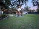 Beautiful backyard with string lights, lush lawn, and manicured landscaping at 7101 N 9Th St, Tampa, FL 33604