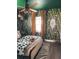 Tropical bedroom showcasing lush wallpaper, bohemian decor, and natural light at 7101 N 9Th St, Tampa, FL 33604