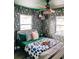 Stylishly decorated bedroom features striking floral wallpaper and a unique ceiling fan at 7101 N 9Th St, Tampa, FL 33604