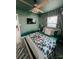 Charming bedroom features a bed, ceiling fan, and stylish jungle-themed wallpaper at 7101 N 9Th St, Tampa, FL 33604