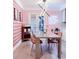 Modern dining room showcasing pink walls, unique light fixture and bar cart with neon sign at 7101 N 9Th St, Tampa, FL 33604