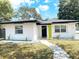 Single-story home with a well-maintained lawn and charming walkway to the front door at 7101 N 9Th St, Tampa, FL 33604