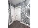 Hallway with geometric wallpaper pattern and white doors for a modern, unique style at 7101 N 9Th St, Tampa, FL 33604