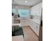 Bright kitchen featuring white cabinets, subway tile backsplash, stainless steel appliances, and quartz countertops at 7101 N 9Th St, Tampa, FL 33604