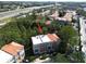 Condo building with a red tile roof surrounded by trees with highway access in the distance at 805 100Th N Ave, St Petersburg, FL 33702