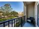 View from a cozy balcony with seating overlooking a tree-lined street and neighborhood homes at 805 100Th N Ave, St Petersburg, FL 33702