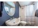 Stylish bathroom featuring a deep navy wall, oval mirror, shower, and toilet at 805 100Th N Ave, St Petersburg, FL 33702