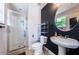 Modern bathroom with glass-enclosed shower, pedestal sink, and sleek shelving unit at 805 100Th N Ave, St Petersburg, FL 33702