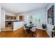 A dining room adjacent to the kitchen features modern light fixtures and a round table with seating at 805 100Th N Ave, St Petersburg, FL 33702