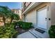 Cozy townhouse entrance featuring 'Home' welcome mat, tropical plants, and a convenient doorbell at 805 100Th N Ave, St Petersburg, FL 33702
