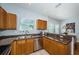 An open kitchen features stainless steel appliances, brown cabinetry, and granite countertops at 805 100Th N Ave, St Petersburg, FL 33702