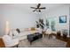 Bright living room with hardwood floors, a ceiling fan, and a comfortable white couch with modern decor at 805 100Th N Ave, St Petersburg, FL 33702