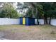 Backyard featuring a blue storage shed with a yellow door, and a white fence at 8303 N 17Th St, Tampa, FL 33604