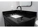 Close-up of a dark vanity with black faucet and granite countertops in updated bathroom at 8303 N 17Th St, Tampa, FL 33604