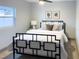 A nicely staged bedroom with a black metal bed frame and bright natural lighting at 8303 N 17Th St, Tampa, FL 33604