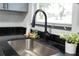 Close up of the kitchen sink with granite countertops, black faucet, and window at 8303 N 17Th St, Tampa, FL 33604