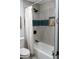 Renovated bath-shower combination featuring neutral tiling and dark bronze fixtures at 8303 N 17Th St, Tampa, FL 33604
