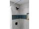 Close-up of the tiled walls in a renovated shower with a rain shower head at 8303 N 17Th St, Tampa, FL 33604