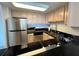 Kitchen with stainless steel appliances and modern black countertops at 880 Mandalay Ave # C704, Clearwater Beach, FL 33767
