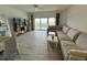 Bright living room with ocean view balcony access, comfortable sofa, and modern decor at 880 Mandalay Ave # C704, Clearwater Beach, FL 33767