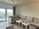 Bright living room with an expansive sectional sofa and modern furnishings at 880 Mandalay Ave # C704, Clearwater Beach, FL 33767