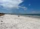 Wide sandy beach with clear skies, calm water, and a few people enjoying the scenery at 880 Mandalay Ave # C704, Clearwater Beach, FL 33767