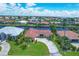 Aerial view of a single Gathering home featuring a circular driveway, mature palms, and a lush, green lawn at 890 Coronado Dr, Punta Gorda, FL 33950