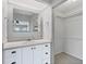 Well-lit bathroom with white vanity, a mirrored cabinet, and access to a walk-in closet at 890 Coronado Dr, Punta Gorda, FL 33950