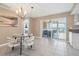 Cozy dining area with a modern chandelier, round table, access to lanai, and stylish decor at 890 Coronado Dr, Punta Gorda, FL 33950