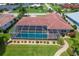 Aerial view of the screened-in pool and backyard landscaping of a single-Gathering home with a tile roof at 890 Coronado Dr, Punta Gorda, FL 33950