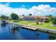 Back exterior view of waterfront property, featuring screened lanai, dock, boat lift, and lush green lawn at 890 Coronado Dr, Punta Gorda, FL 33950