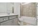 Bathroom featuring a tile shower/tub combo and vanity with gray cabinets at 9535 Coastline Way, Parrish, FL 34219