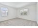 Bright bedroom with neutral carpet, two windows with blinds, and fresh white walls at 9535 Coastline Way, Parrish, FL 34219