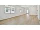 Bright living room featuring laminate wood floors, large windows with blinds, and white walls at 9535 Coastline Way, Parrish, FL 34219