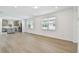 Spacious living room with wood laminate flooring, bright natural light, with an open view into the kitchen at 9535 Coastline Way, Parrish, FL 34219