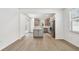 Open concept living space with gray toned laminate wood flooring and a view of the kitchen at 9535 Coastline Way, Parrish, FL 34219