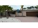 Charming single-story home with brick driveway and lush palm trees in a tropical setting at 997 Boca Ciega Isle Dr, St Pete Beach, FL 33706