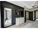 Modern bedroom featuring dark accent wall, dresser with TV, and light wood flooring at 10130 Deercliff Dr, Tampa, FL 33647