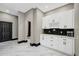 Chic butler's pantry with stylish white cabinetry, black backsplash, and elegant marble flooring at 10130 Deercliff Dr, Tampa, FL 33647