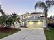 Two-story home featuring well-maintained landscaping and a spacious three car driveway and tropical trees at 10130 Deercliff Dr, Tampa, FL 33647