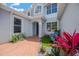 Charming two-story home with well-manicured front yard featuring decorative plants and brick pathway at 10130 Deercliff Dr, Tampa, FL 33647