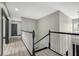 Upstairs hallway with natural light and black/white banister details leads to several bedrooms at 10130 Deercliff Dr, Tampa, FL 33647