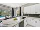 Bright kitchen featuring quartz countertops, sleek cabinetry, and a view of the outdoor pool area at 10130 Deercliff Dr, Tampa, FL 33647