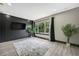 Living room with decorative rug, large window with curtains and green leafy plants at 10130 Deercliff Dr, Tampa, FL 33647