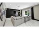 Modern living room with gray sectional sofa, dark wood paneling, and sliding door access to the backyard at 10130 Deercliff Dr, Tampa, FL 33647