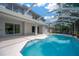 Exterior view of the home's pool area with a screened enclosure and a spacious deck at 10130 Deercliff Dr, Tampa, FL 33647
