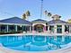 Relaxing poolside scene with comfortable seating, umbrellas, and a refreshing pool reflecting the clubhouse at 10130 Deercliff Dr, Tampa, FL 33647